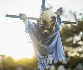 zombie corpse hanging on a cross with golden hour sunlight in the background Halloween decoration