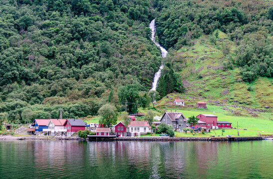 The picturesque hamlet of Tufto and the Tuftofossen (the waterfall) on the shores of the Naeroyfjord, in Vestland County, Norway.