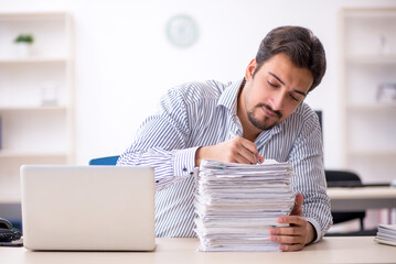 Young male employee and too much work in the office