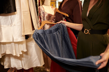 Obraz na płótnie Canvas Woman buying skirt in clothes shop