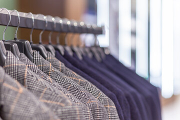 Racks with different men's suits in a men's clothing boutique. LED lights copy space on background.