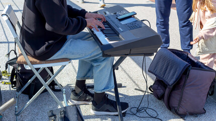 Street musician plays synthesizer, people throw money