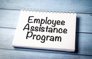 paper with the text EAP Employee Assistance Program on blue wooden background