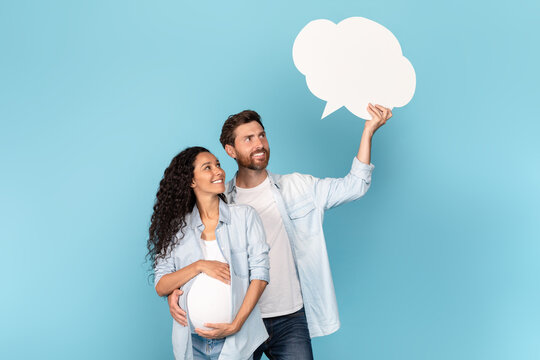 Cheerful millennial caucasian man with beard hug pregnant arab woman with belly, look at abstract cloud - Powered by Adobe