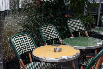 Green and yellow chair and table in 
terrace of a Parisian café. NFC menus are visible on the tables.