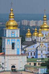 Fototapeta na wymiar Monastery and church in Kiev viewed from far, with majestic city backdrop behind. Churches in kiev, blue church with golden roof