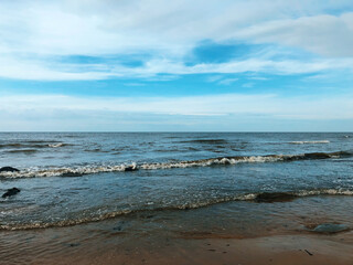 Cloudy blue sky above a blue surface of the sea.
