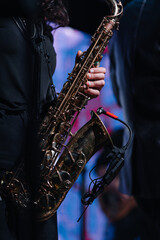 Naklejka premium Soprano saxophone in hands on a dark background. Alto sax musical instrument closeup