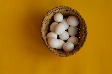 Wicker basket with chicken white eggs. Store eggs in one basket. Fresh eggs for breakfast.