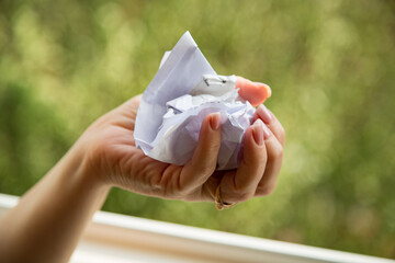 Woman's hand crumpling papers or bills. Unwillingness to put up with large payments. Crumpled paper in hand is a sign of protest against large payments. Crush an invalid contract.