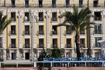 Naklejka premium Nice, France - 29.09.2022 : The facade of the hotel Le Royal in Nice and the man in the window looking at the sea