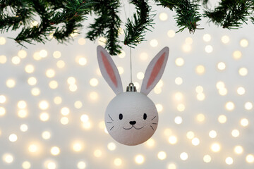 Handmade christmas ball with ears in form of bunny hanging on the christmas tree.