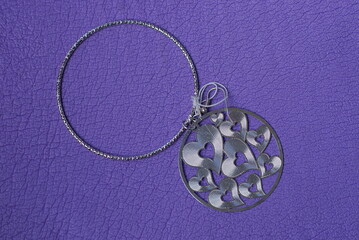 a jewel of two gray silver rings earrings with small hearts lies on a purple table