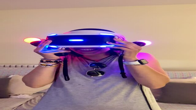 vertical video of Girl in casual clothes using augmented reality device. young woman playing VR glasses
