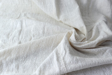 An image of the top corner of a pile of white cotton fabric, wrinkled, wavy, for use in the background.