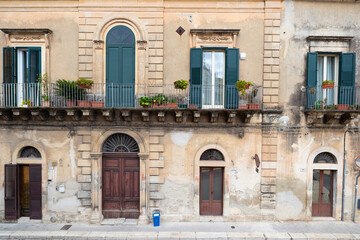 Fototapeta na wymiar Drzwi i okna starych kamienic na Sycylii