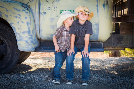 Two Young Boys Wearing Cowboy Hats Leaning Against Antique Truck.