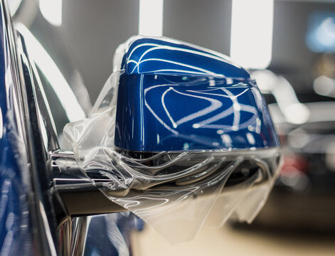 The process of installing PPF on the side mirror. PPF is a protective film for paint that protects the paint from scratches and gravel.Anti-gravity protection. PFF is installed. Car wrapping close-up.