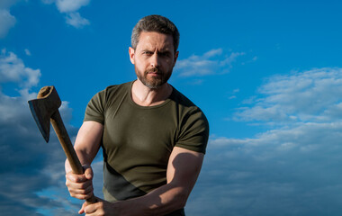 man hitting with axe. caucasian man hold ax. brutal man on sky background