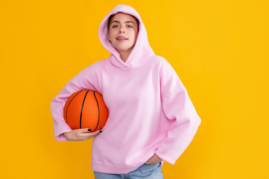 hipster sporty girl student with basketball ball on yellow background