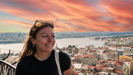 Young tourist woman sightseeing with Istanbul landscape at sunset. Young beautiful woman watching Istanbul from the Galata Tower