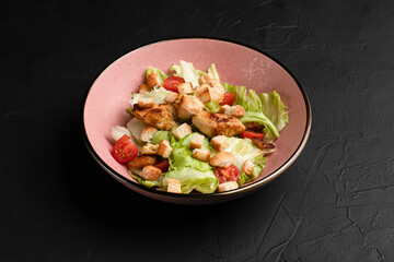 Caesar salad, fresh caesar salad with crackers on a black background