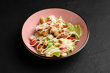 Caesar salad, fresh caesar salad with crackers on a black background