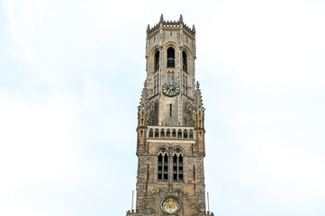 Fototapeta na wymiar Bruges, Belgium: Belfry of Bruges. Medieval clock tower on Market Square. Historical buildings in city centre. 