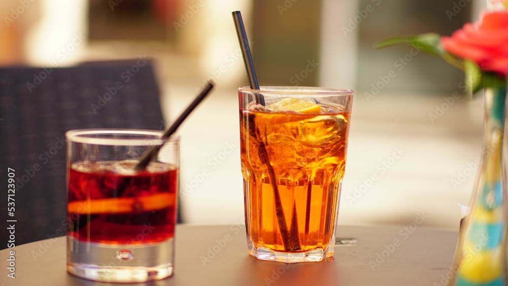 Wall mural closeup of two cups of drinks with black straws placed on the table