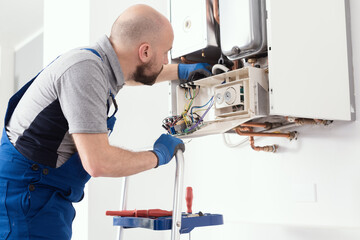 Professional engineer servicing a boiler at home