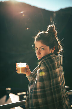 Brunette girl having a coffee for breakfast next to the terrace