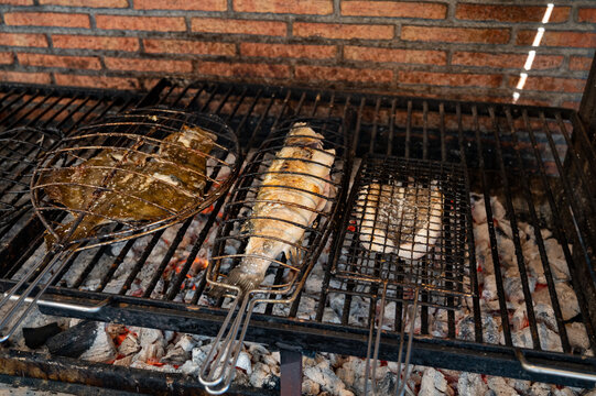 Fresh fish grilling on old charcoal parrillas build outside of buildings in small fisherman's village Getaria, Basque Country, Spain