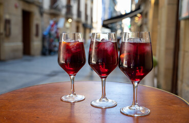 Glasses of cold sangria wine served outdoor in bar with view on old street in San Sebastian, Basque Country, Spain