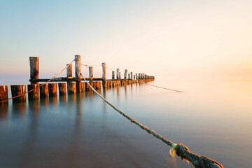 Beautiful scene of long wooden pie over water with blur bright sky in Zingst by Baltic Sea