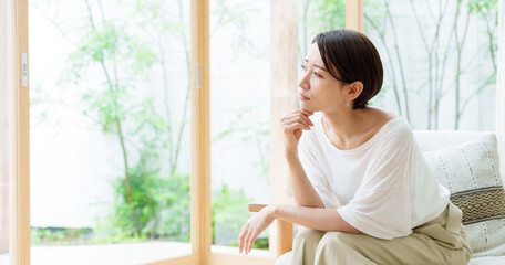 リビングで考え事をする女性