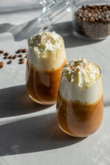Pumpkin spice latte with whipped cream on a table. Two glasses of hot autumn drink.