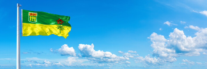 Saskatchewan - Canada flag waving on a blue sky in beautiful clouds - Horizontal banner

