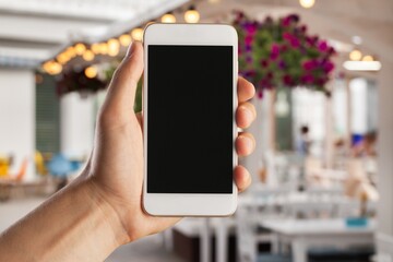 Human hands hold a phone with a blank screen