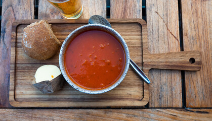 Bowl of tomato soup served with bread and glass of beer, typical dish of Dutch cuisine