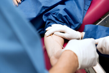 medical procedure, the doctor takes blood from the patient's vein, close-up