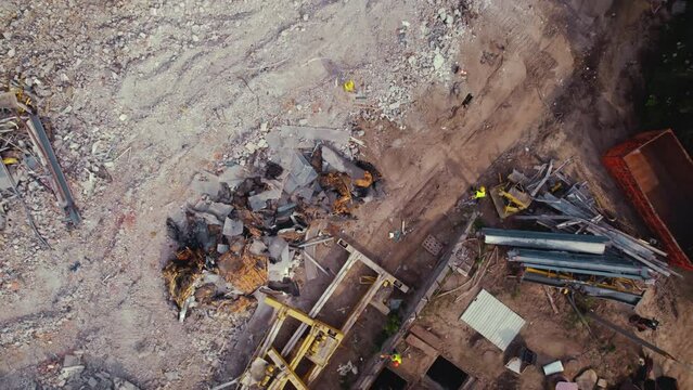 Demolition construction working site. Demolition debris, stone and concrete, building materials, and heavy machinery. Top drone view. High quality 4k footage