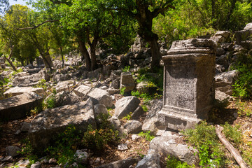Ancient marble statue pedestal among ruins Agora of abandoned city Termessos in Turkey mountains