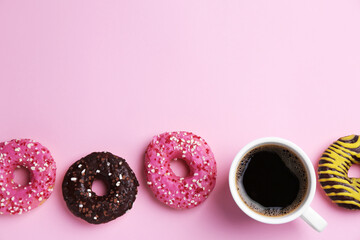 Tasty donuts and cup of coffee on pink background, flat lay. Space for text