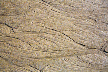 Close up of patterns on the sand from sea water after low tide, Spain