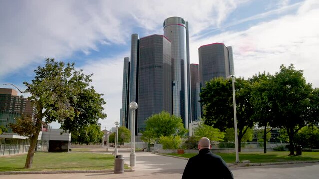 Man walking toward Renaissance Center in Detroit, Michigan with gimbal video walking behind.