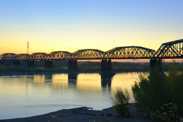 Fototapeta na wymiar Bright dawn at the railway bridge
