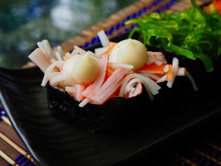 Japanese food with crab sticks, seaweed and mayonnaise 
