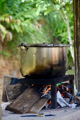 outdoor cooking in a big pot above fire