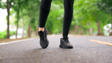 Asian woman warm up leg and ankle engaged in fitness in public park. She  jumping and twist ankle....