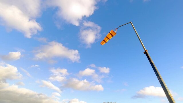 Striped coastline safety wind sock indicator blowing measuring windy weather speed and direction